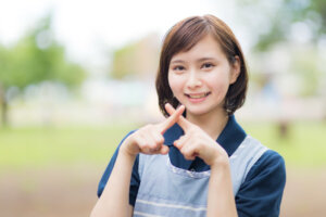 女性がバツマークをしてる画像